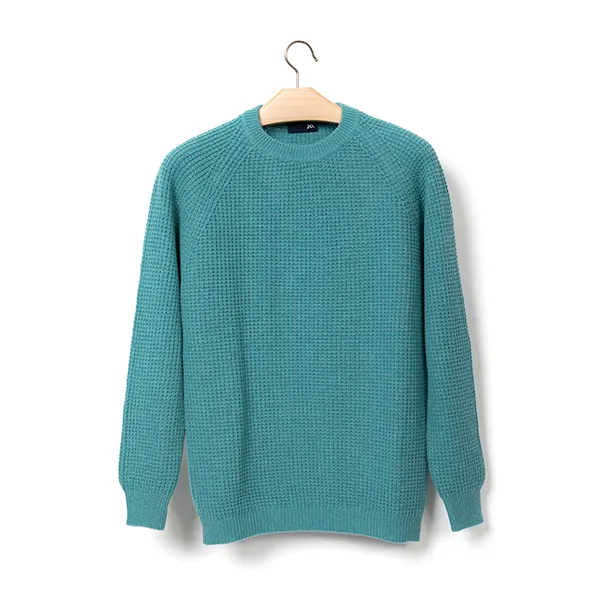 Pull en maille turquoise sur cintre