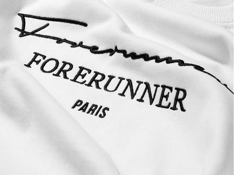 Gros plan sur une broderie noire sur t-shirt blanc